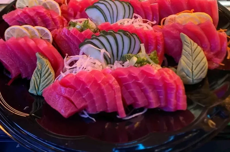 Large catering platter of tuna sashimi fanned out with cucumber and shredded daikon