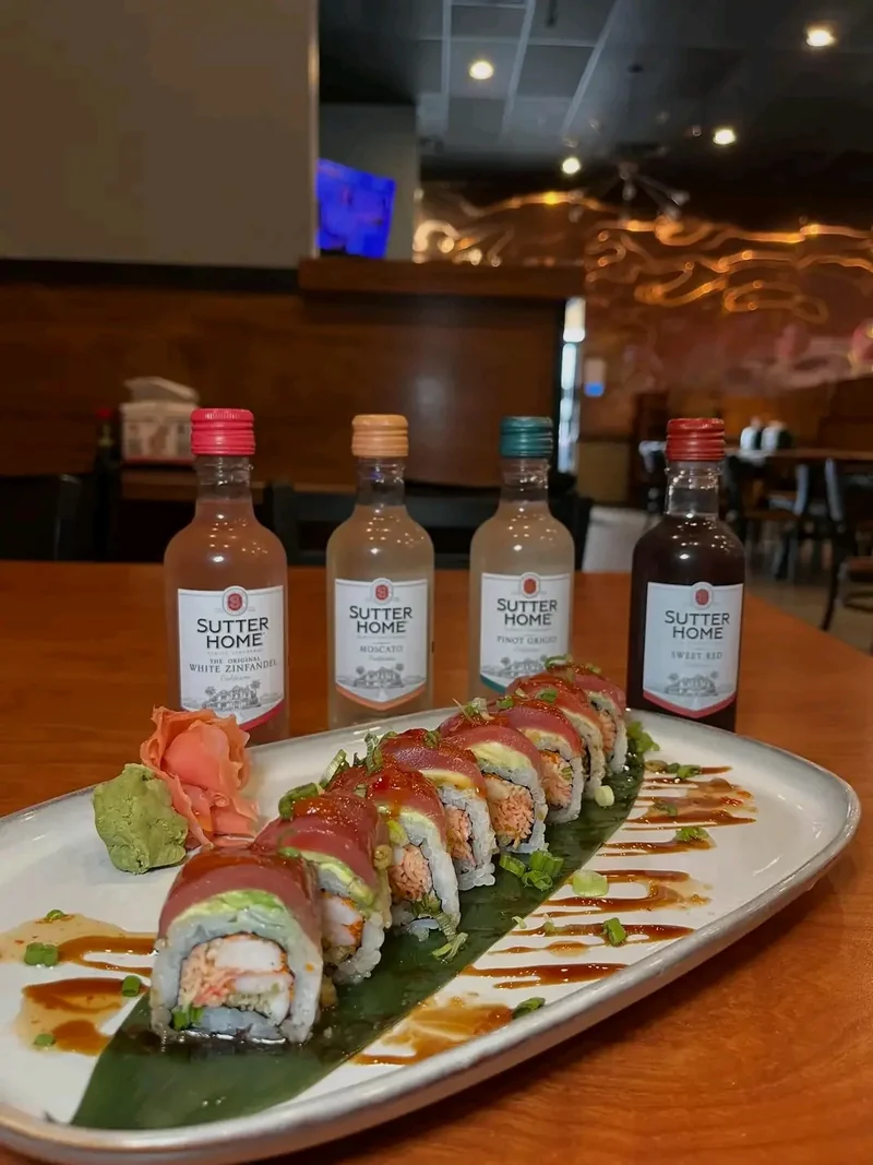 Sushi roll layered with tuna and avocado over eel sauce
