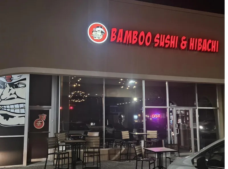 Bamboo Sushi Bar and Hibachi Express storefront lit up in the evening
